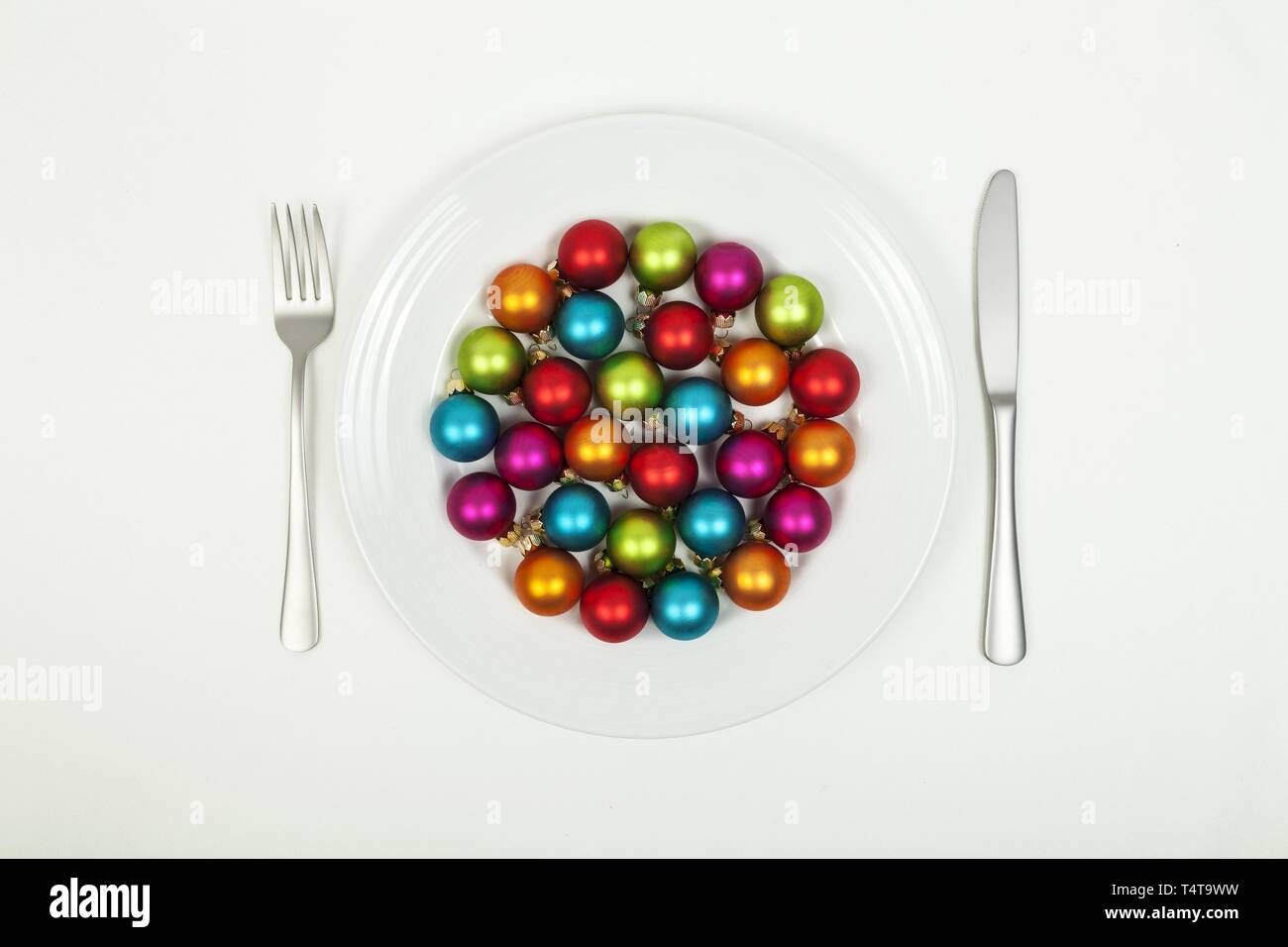 White plate, cutlery, baubles Stock Photo
