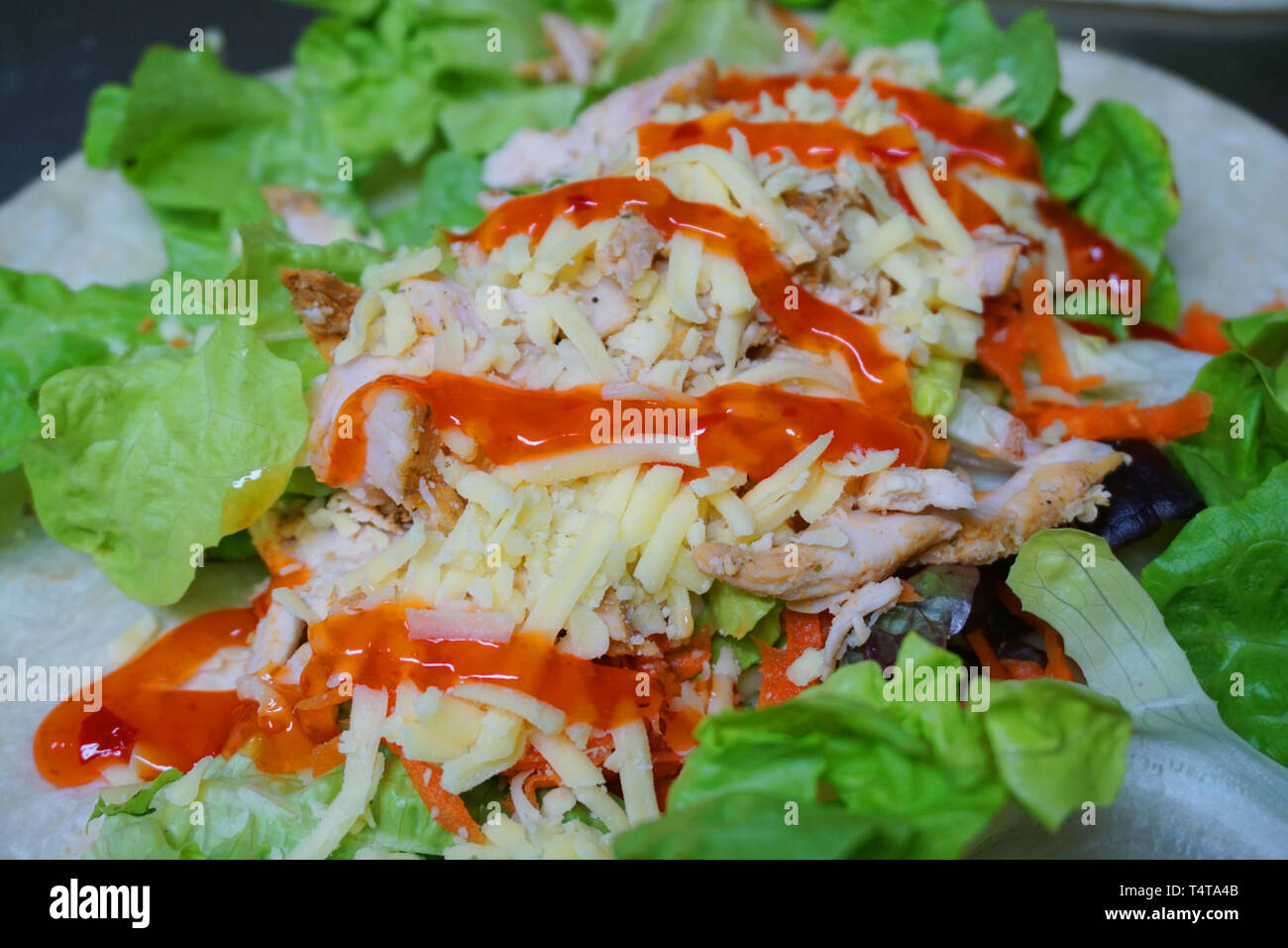 Sandwich wrap with cheese shredded lettuce salad meat tomato satay