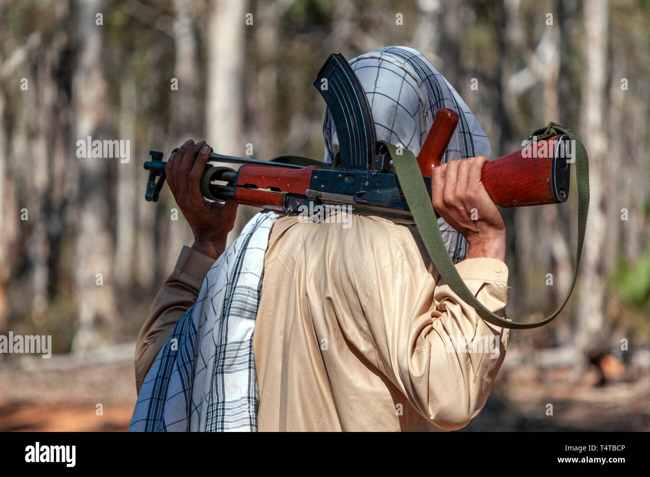 Rear view of an ISIS soldier with a Kalashnikov AK47 assault rifle over his shoulders. Stock Photo