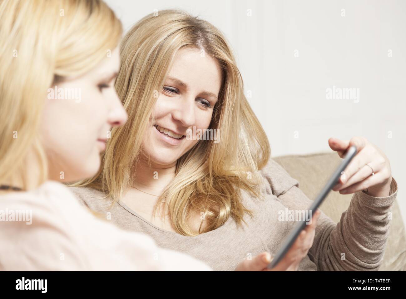 Two women sitting on sofa hi-res stock photography and images - Alamy