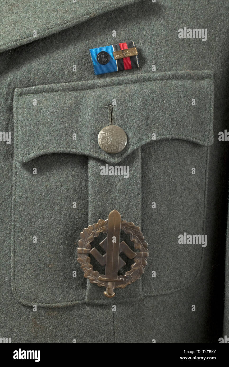 A field tunic M 38 for an SD-Hauptscharführer depot piece from the duty station in Prague Cut in the style of the black tunic, made of field-grey woollen cloth with metal buttons, brown lining with bandage pack pocket and depot stamp 'G.St. Prag'. Black collar patches without piping (from 1942 onwards), slip-on shoulder-boards with police pattern but with black interweaves and middle section. Sleeve eagle and SD sleeve diamond in light-coloured RZM embroidery on black ground. War Merit Cross ribbon, field orders clasp with SS Long Service Award and pinned-on SA Sports Badge, Editorial-Use-Only Stock Photo