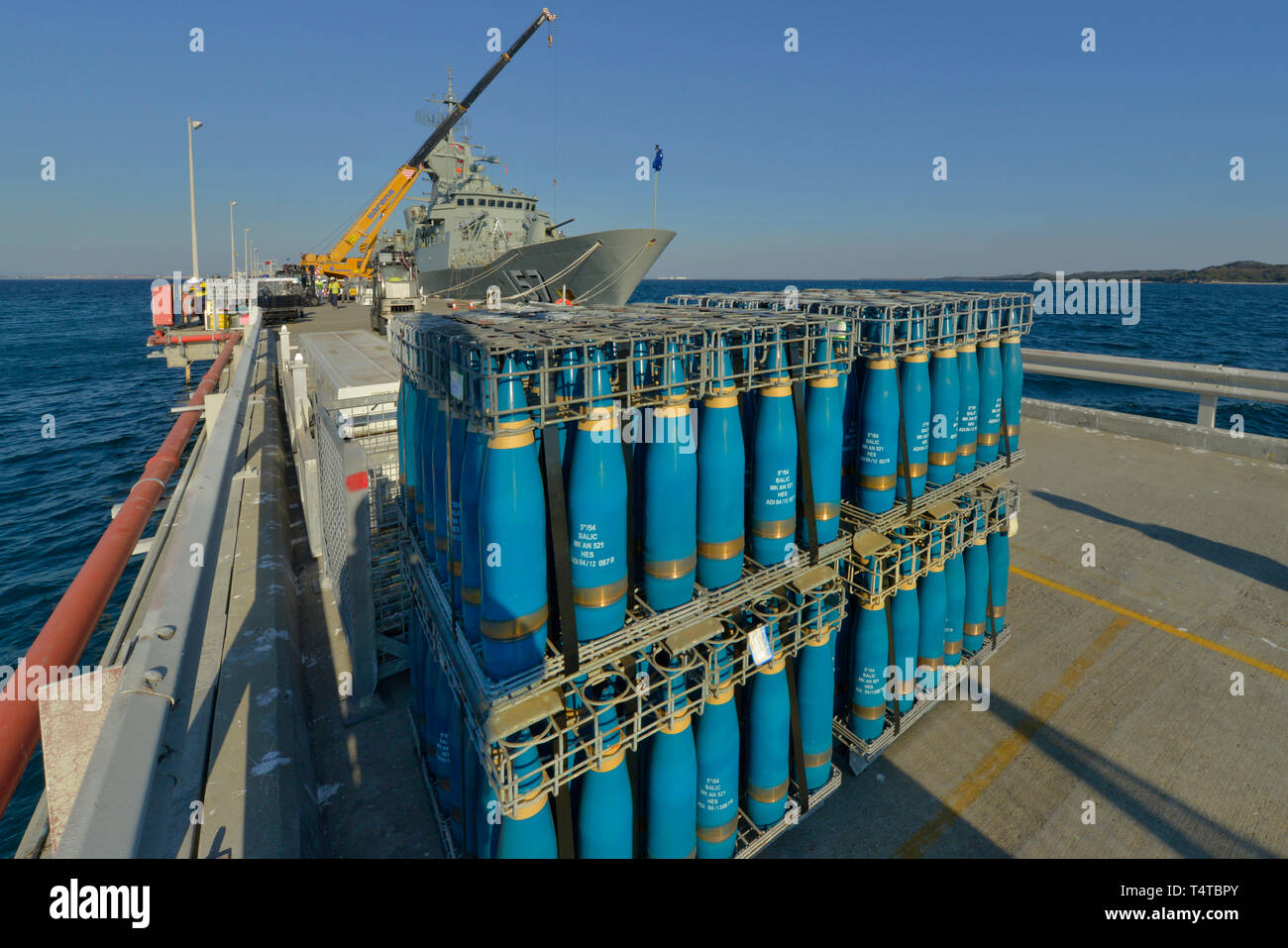 High explosive, naval artillery shell warheads, in a loading crate on a concrete wharf. The shells are awaiting delivery to an RAN frigate. Stock Photo