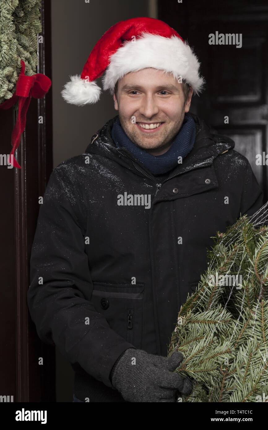 Man with a packaged Christmas tree Stock Photo