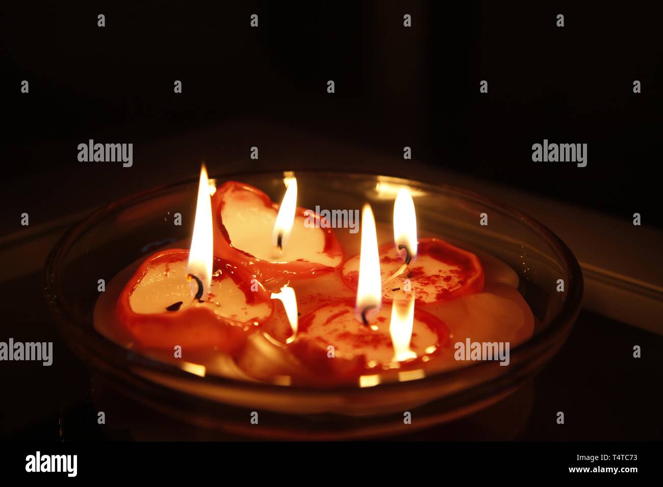 Burning candles in a bowl Stock Photo
