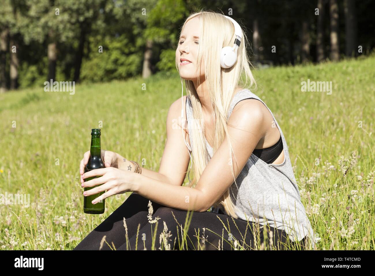 Teen with beer bottle and headphones Stock Photo