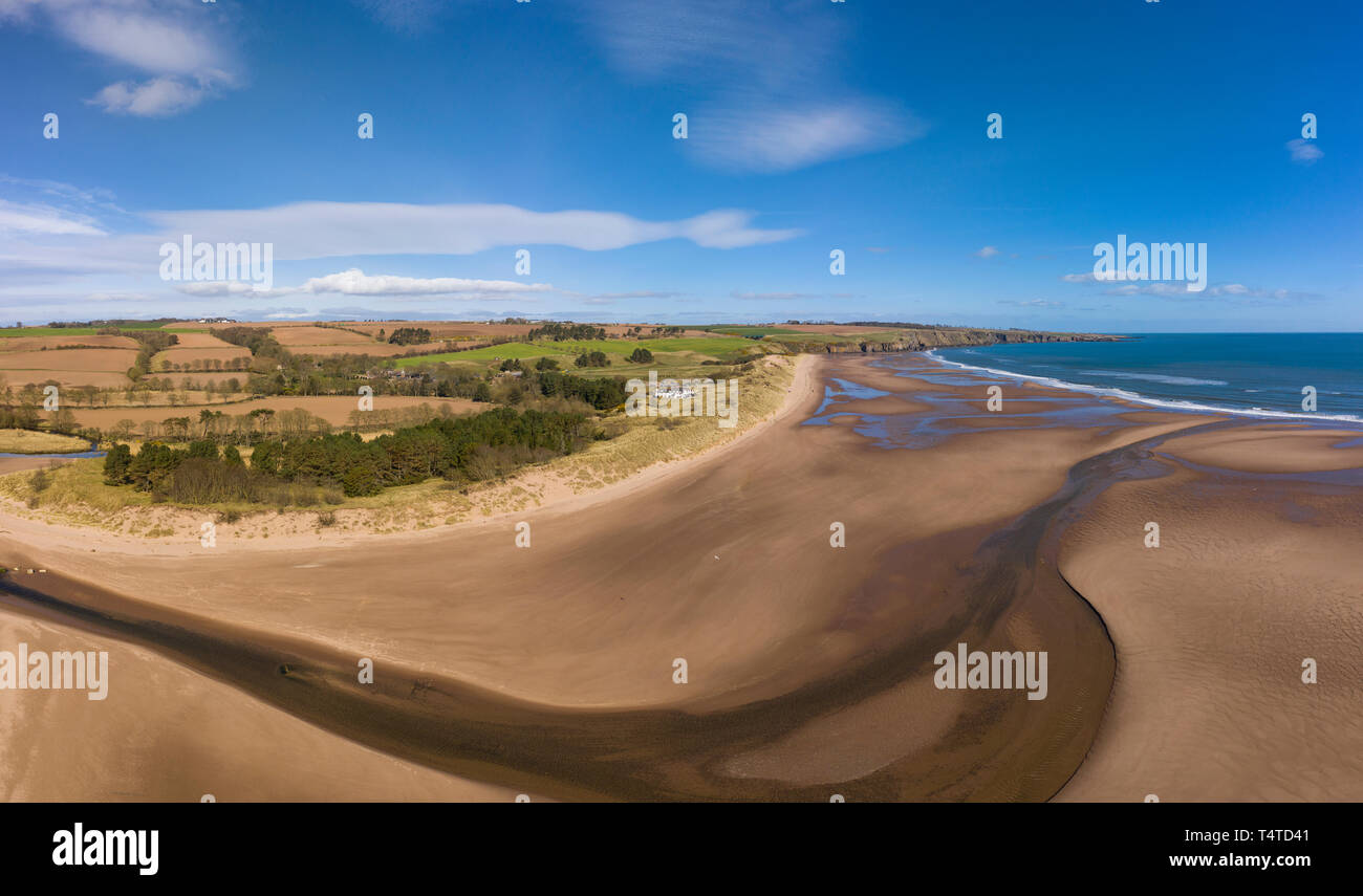 Aerial view of Lunan Water  snakes out to the North Sea bisecting Lunan Bay beach, Angus, Scotland. Stock Photo