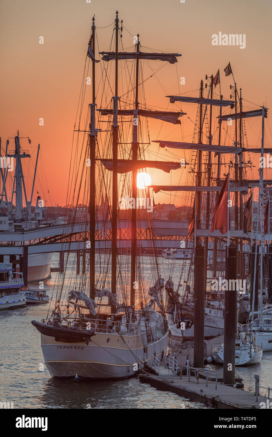 sunset behind sailing ships in Niederhafen port of Hamburg Stock Photo