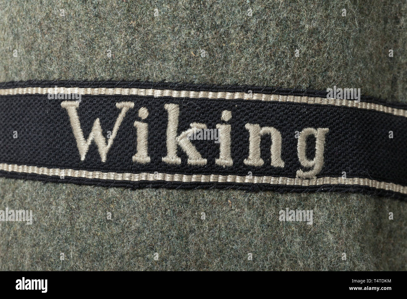 A field tunic of the field-grey special uniform for a member of the Assault Gun Unit of the 5th SS Panzer Division 'Wiking', SS cut with straight button fly and one-piece back made of field-grey woollen cloth with synthetic resin buttons. Partial lining made of steel-grey artificial silk with depot- and size stamps. Black BeVo woven collar patches, black slip-on shoulder boards with red piping. RZM embroidered sleeve eagle on black ground, underneath it sleeve band 'Wiking' in RZM machine-embroidered version for enlisted men. Very rare, barely worn tunic. 20th century, 1930, Editorial-Use-Only Stock Photo
