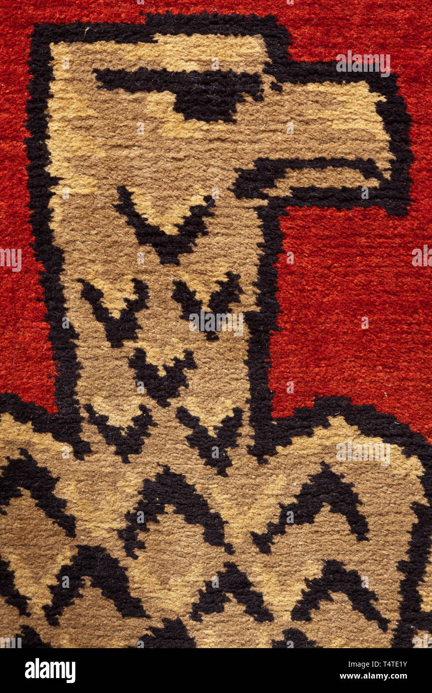A tapestry with national eagle, Wine-red carpet fabric with national eagle (gazing to the right) in the early form of the Allgemeine SS in the centre. The top with stitched edge to insert a flag pole, the bottom with fringes, several bullions missing. The reverse reinforced with netting. At the bottom holes of approximately 2 cm. Carpet unmarked, without maker's inscription. Dimensions 220 x 107 x 1 cm. historic, historical 20th century, Editorial-Use-Only Stock Photo