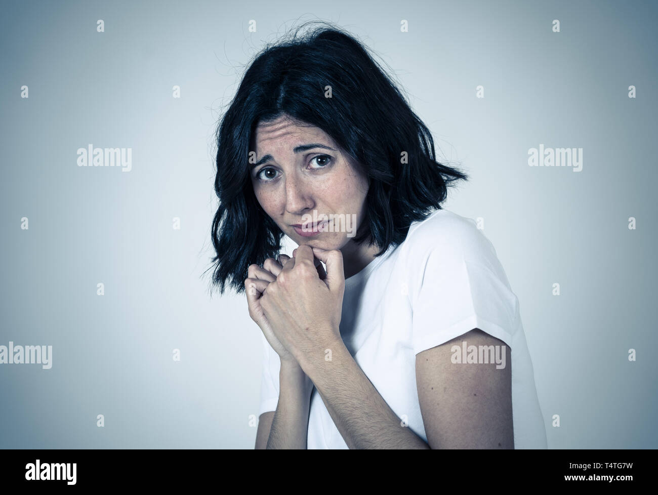 Close up of young woman with frightened eyes, shocked, cowered ...