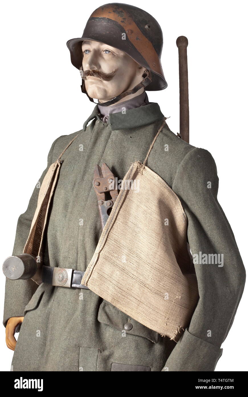 A uniform ensemble for an assault pioneer in trench warfare. Steel helmet M 1916 in 'Mimicry' camouflage with maker's marks. Three-piece inner liner, chin strap on button 91. Field-grey tunic M 1915 with folding collar, depot stamp inside. Grey field trousers with leather trim and depot stamp inside. Prussian belt buckle, painted field-grey with belt. Grey puttees (made later), leather lace-up boots with nailed soles. Wire cutters with maker 'Hückinghaus'. Hand grenade bag of heavy sackcloth. Hand grenade for decoration, with legend and pull cord, Additional-Rights-Clearance-Info-Not-Available Stock Photo