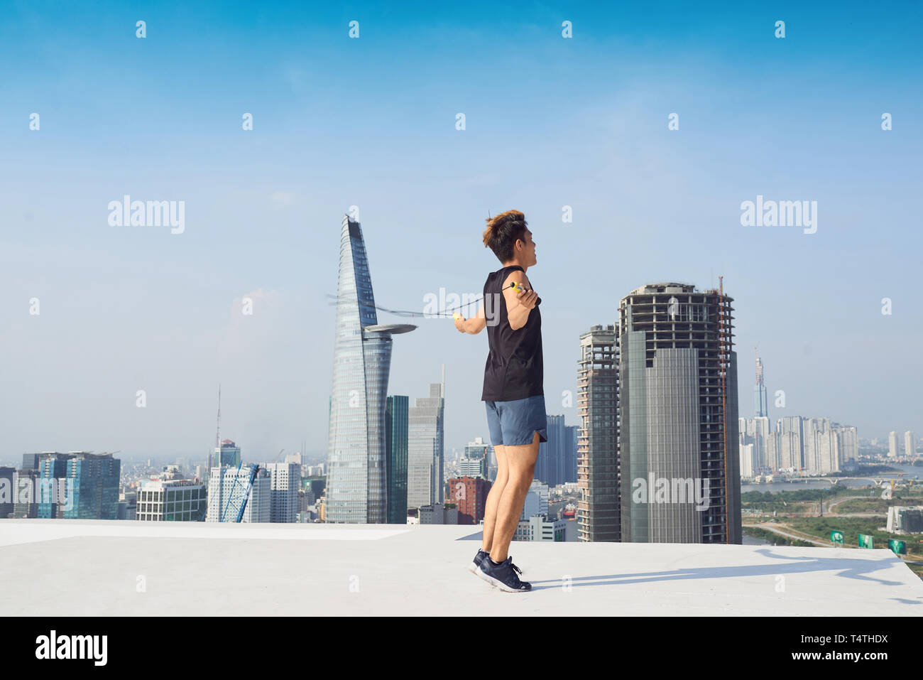 fitness, sport, people, exercising and lifestyle concept - man skipping with jump rope outdoors Stock Photo