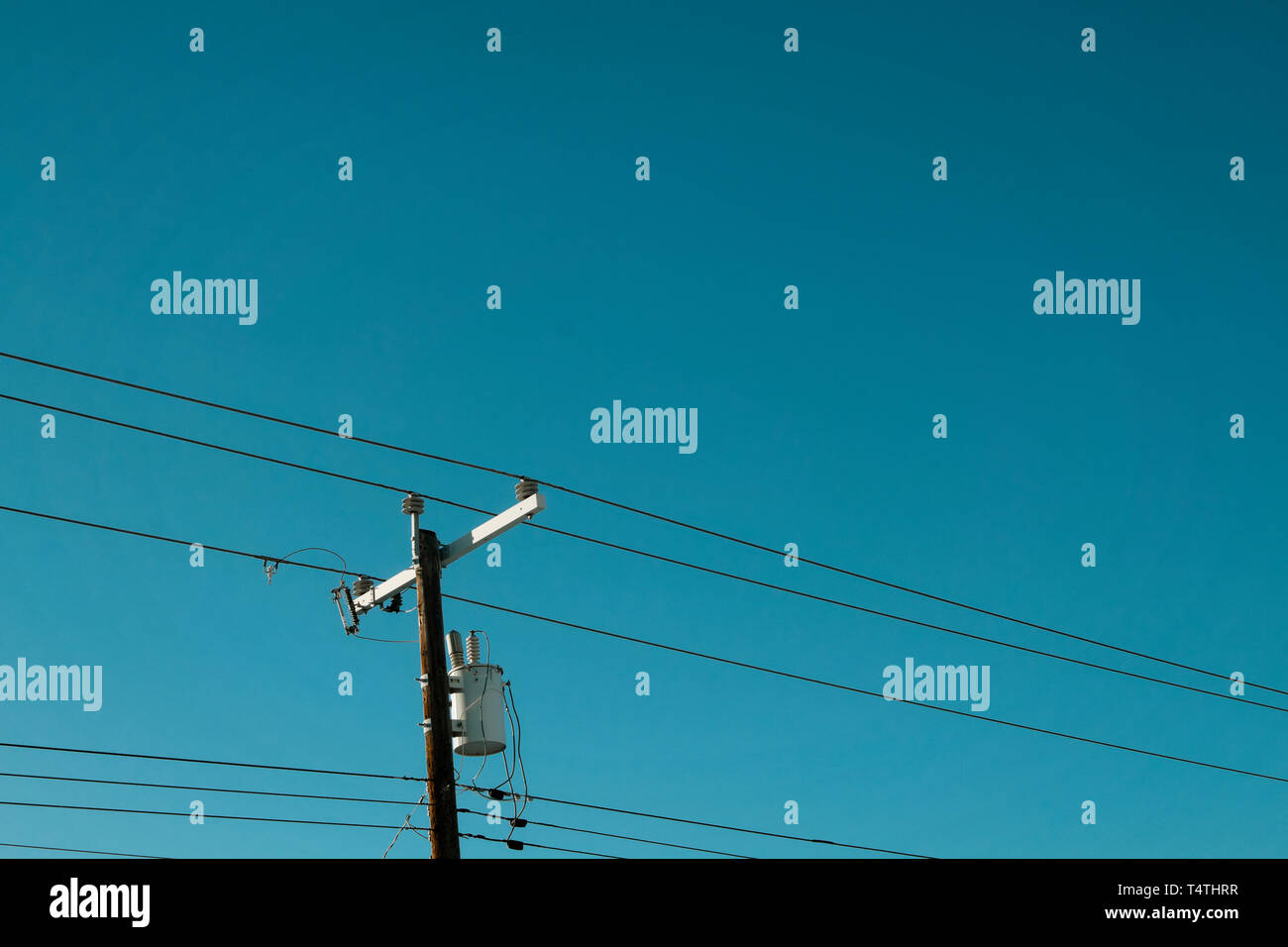 Power lines below a blue sky in the summer Stock Photo - Alamy
