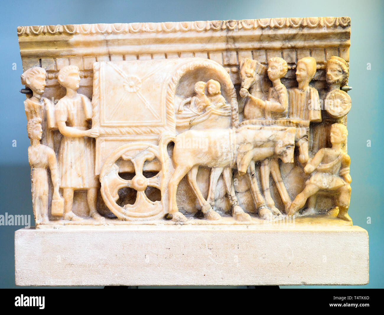 Front panel from an alabaster cinerary urn with a carved scene Etruscan, 100-50 BC Probably from Volterra Accompained by attendants, a couple is shown riding in a covered wagon (carpetum) on their journey into the underworld. Stock Photo