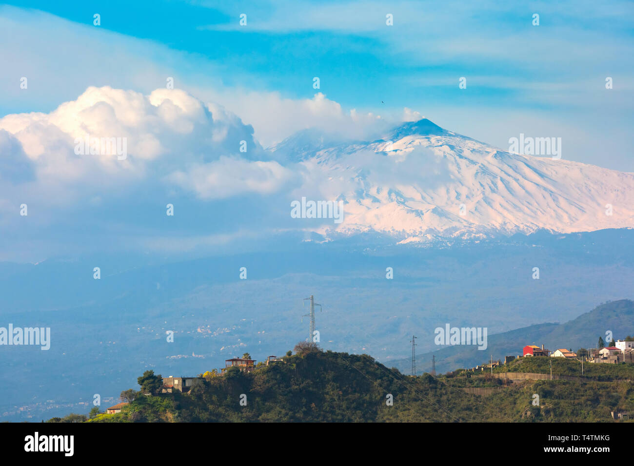 Smoking snow-capped Mount Etna volcano at sunrise, as seen from Taormina, Sicily Stock Photo
