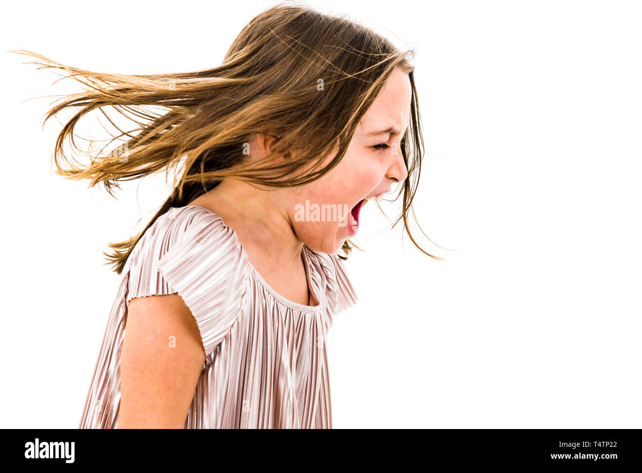 Little girl child yelling, shouting and screaming with bad manners. Angry upset girl is arguing with emotional expression on face. Frontal profile vie Stock Photo
