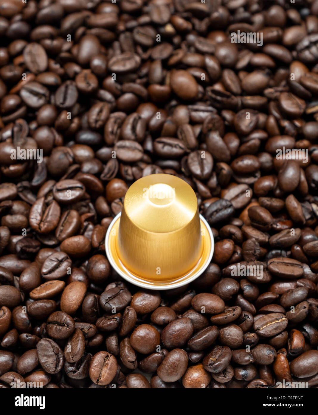 Golden coffee capsule on the roasted coffee bean for use to the Nespresso  machine,(copy space Stock Photo - Alamy