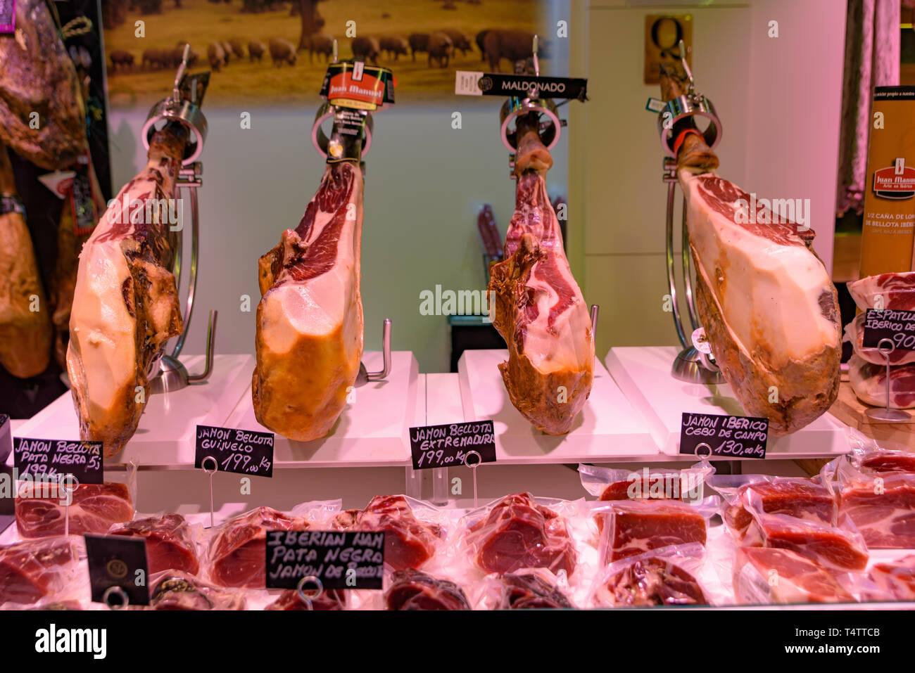 The stalls selling Jamón Serrano, the dry-cured Spanish ham made with Iberian pigs, in Barcelona, Spain Stock Photo