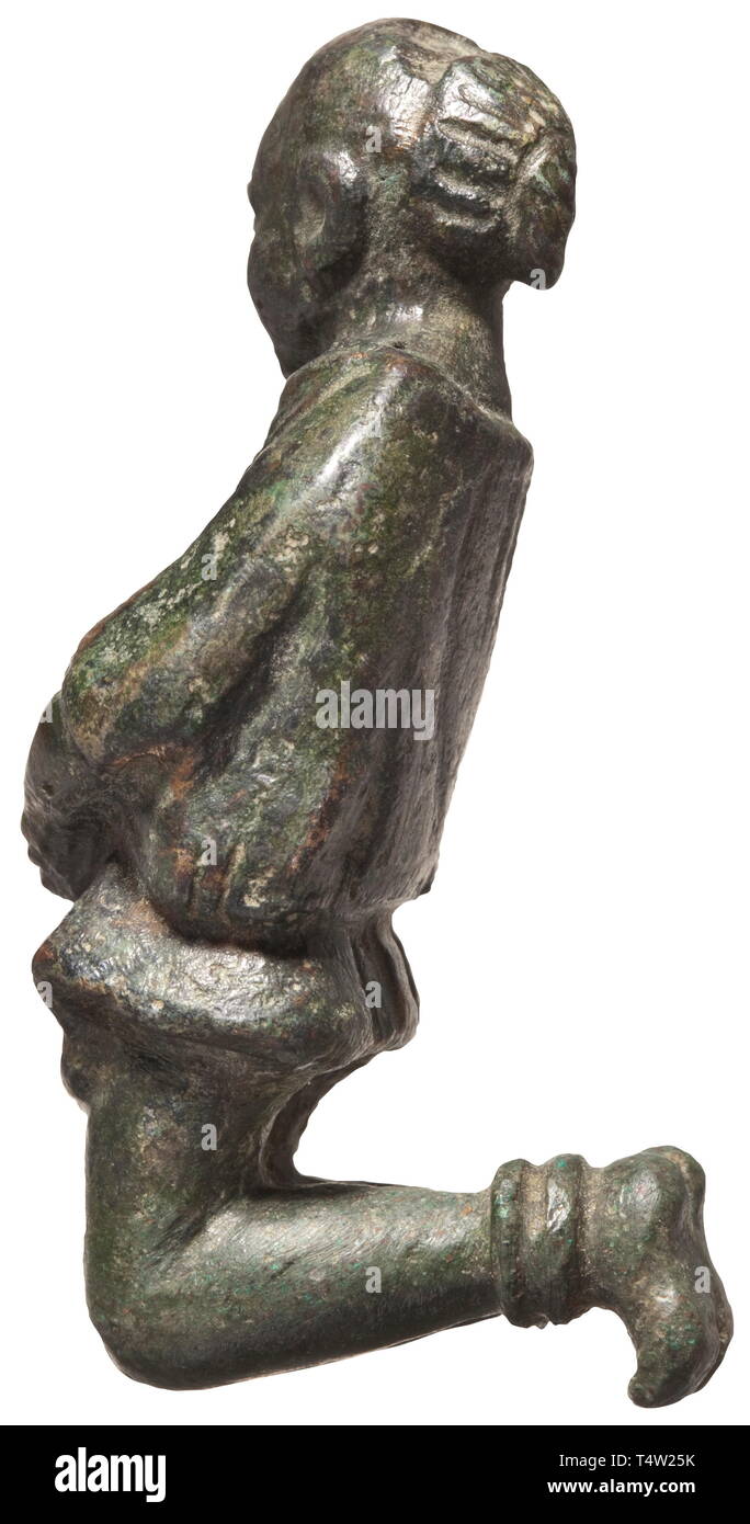 A Roman figure of a Germanic prisoner, 2nd/3rd century AD Bronze with dark green patina. Kneeling male figure with bound hands and feet and typical hairstyle. Height 6 cm. Provenance: South German private collection, 1970s and later. historic, historical, Roman Empire, ancient world, ancient times, ancient world, Additional-Rights-Clearance-Info-Not-Available Stock Photo