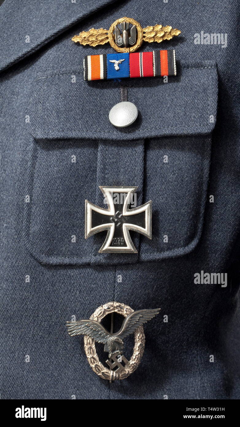 A walking-out uniform for a lieutenant of the flying corps. A coat of Luftwaffe blue gabardine with silver collar cord and buttons, silver-embroidered insignia and silver adjutantïs lanyard, the silk lining with label 'Verkaufsabteilung der Luftwaffe - Berlin'. Pinned-on Pilotïs Badge in non-ferrous metal issue (reverse cloverleaf logo of 'BSW'), an Iron Cross 1st Class (near mint with frosted silvering) and a Luftwaffe Squadron Clasp in Gold for Bombers in non-ferrous metal issue. Included are the corresponding breeches with leg laces. historic, historical, Air Force, bran, Editorial-Use-Only Stock Photo