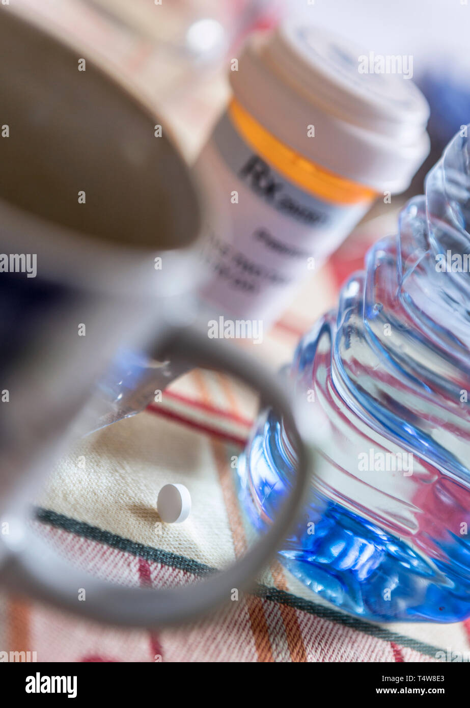 Medication during breakfast, capsules next to a glass of water, conceptual image Stock Photo