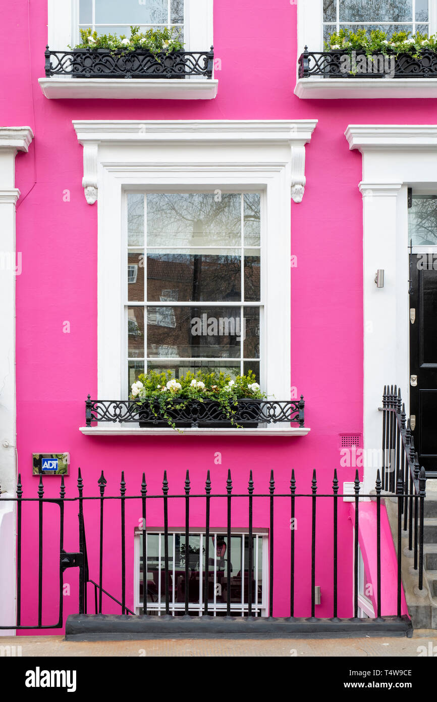 Colourful pink terraced house and window box with flowers in Denbigh