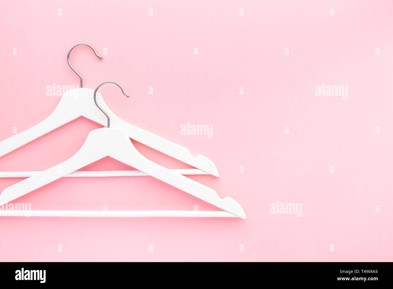 Creative top view flat lay white wooden hangers pastel millennial pink ...