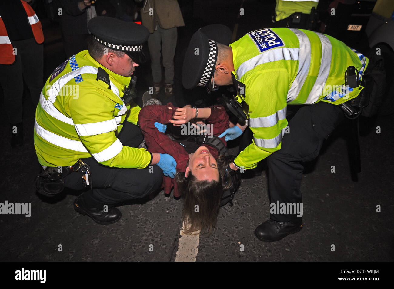 A climate activist with police officers at an Extinction Rebellion demonstration in Parliament Square, London. Londoners face a fourth day of disruption in the capital, despite nearly 400 arrests. Stock Photo