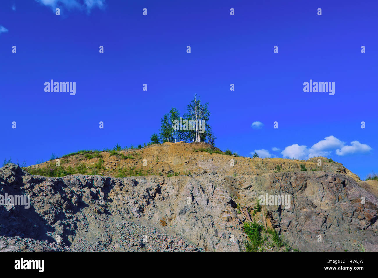 Summer landscape rocks overgrown with rare forest against the blue sky ...