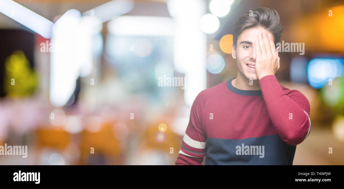 Young handsome man over isolated background covering one eye with hand ...