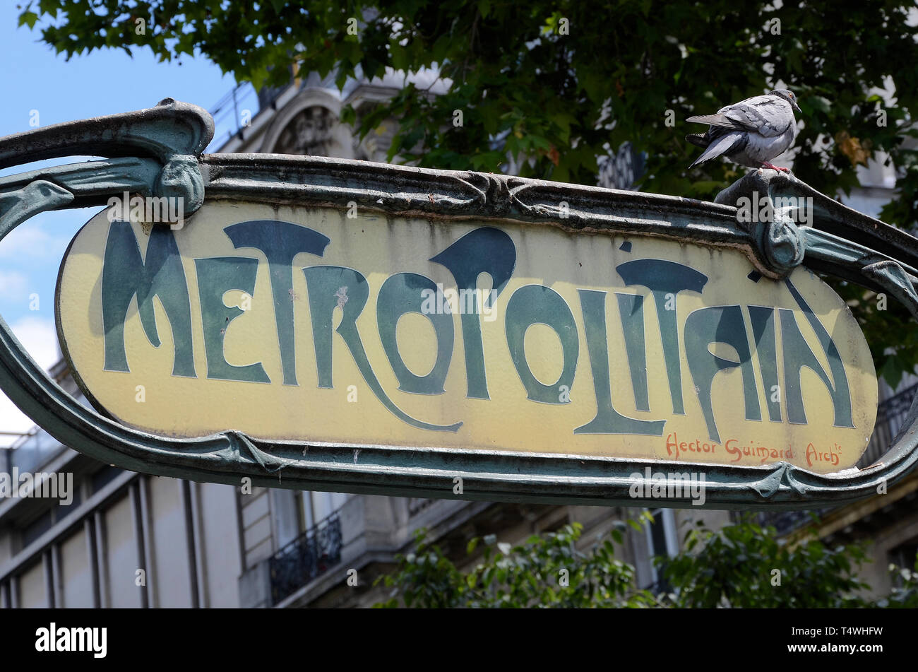 Metropolitain Paris Metro vintage sign in Paris, France, Europe. Hector Guimard Arch design writing. Classic French landmark design with pigeon Stock Photo