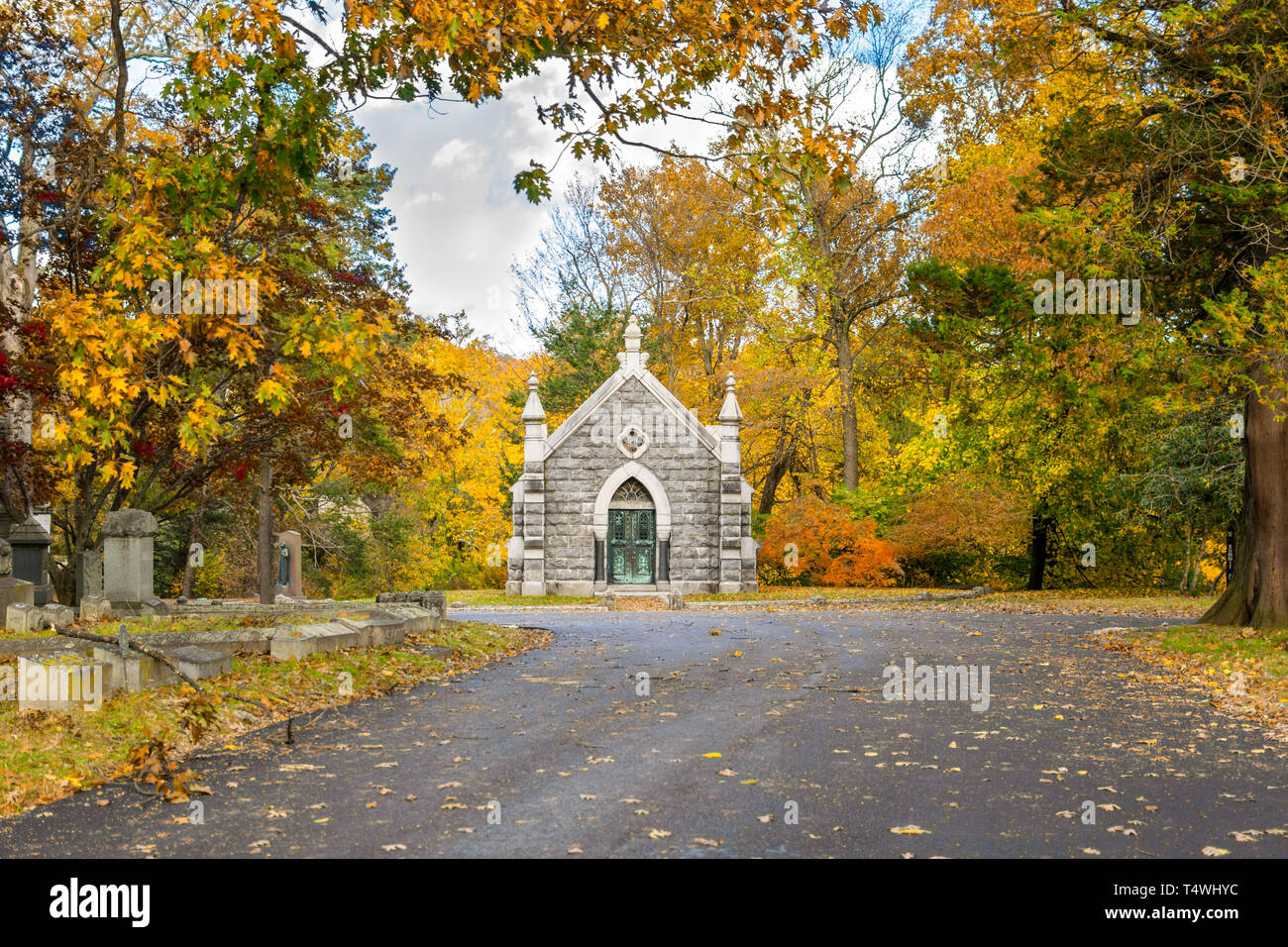 Small mausoleum at Sleepy Hollow Cemetery surrounded by autumnal fall