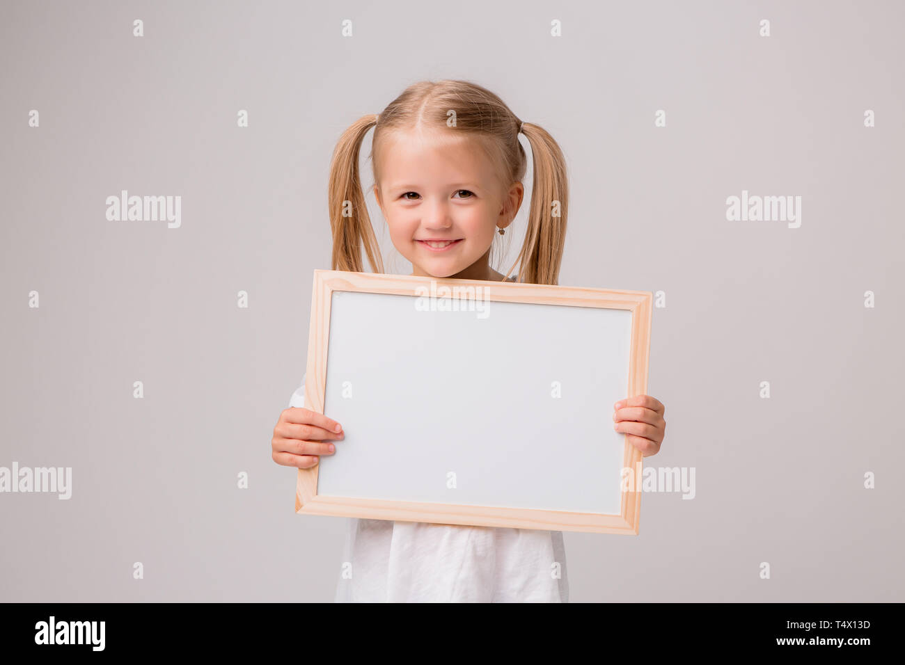 Portrait Of Baby Girl Holding White Drawing Board On White Background Young Girl With Blond Hair Is Holding A Drawing Board In Her Hands White Isola Stock Photo Alamy Portrait Of Baby Girl Holding White Drawing Board On White Background Young Girl With Blond Hair Is Holding A Drawing Board In Her Hands White Isola Stock Photo Alamy