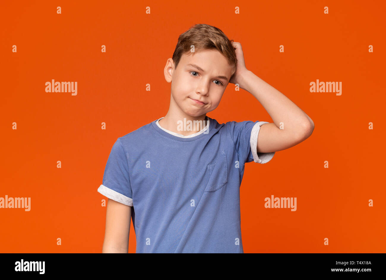 Confused boy scratching his head with puzzled expression Stock Photo