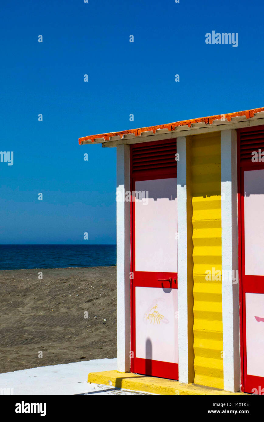 Red and white seaside cabin on the deserted beach, in April, with the blue sky in the background Stock Photo