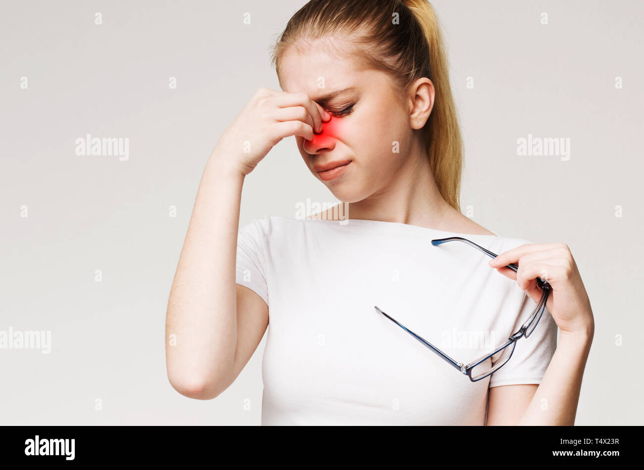 Tired woman suffering from eye pain, massaging nose Stock Photo Alamy