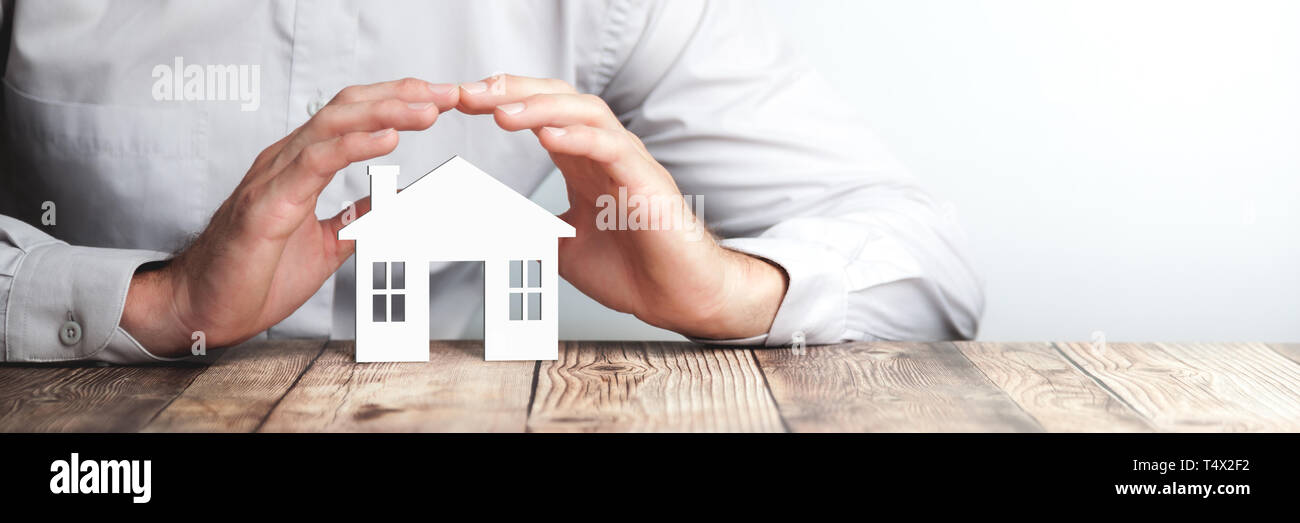 Protecting Hands Over House - Home Security And Protection Concept Stock Photo