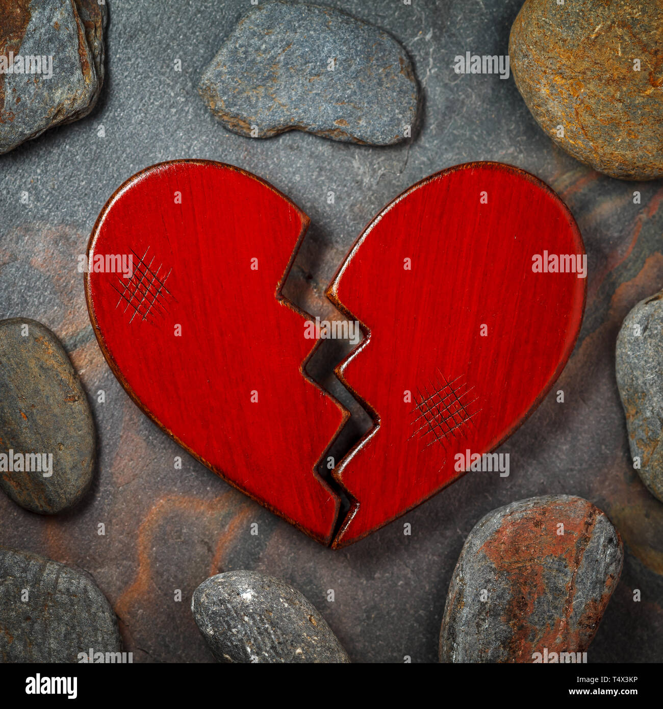 Broken wooden red heart on background. Stock Photo