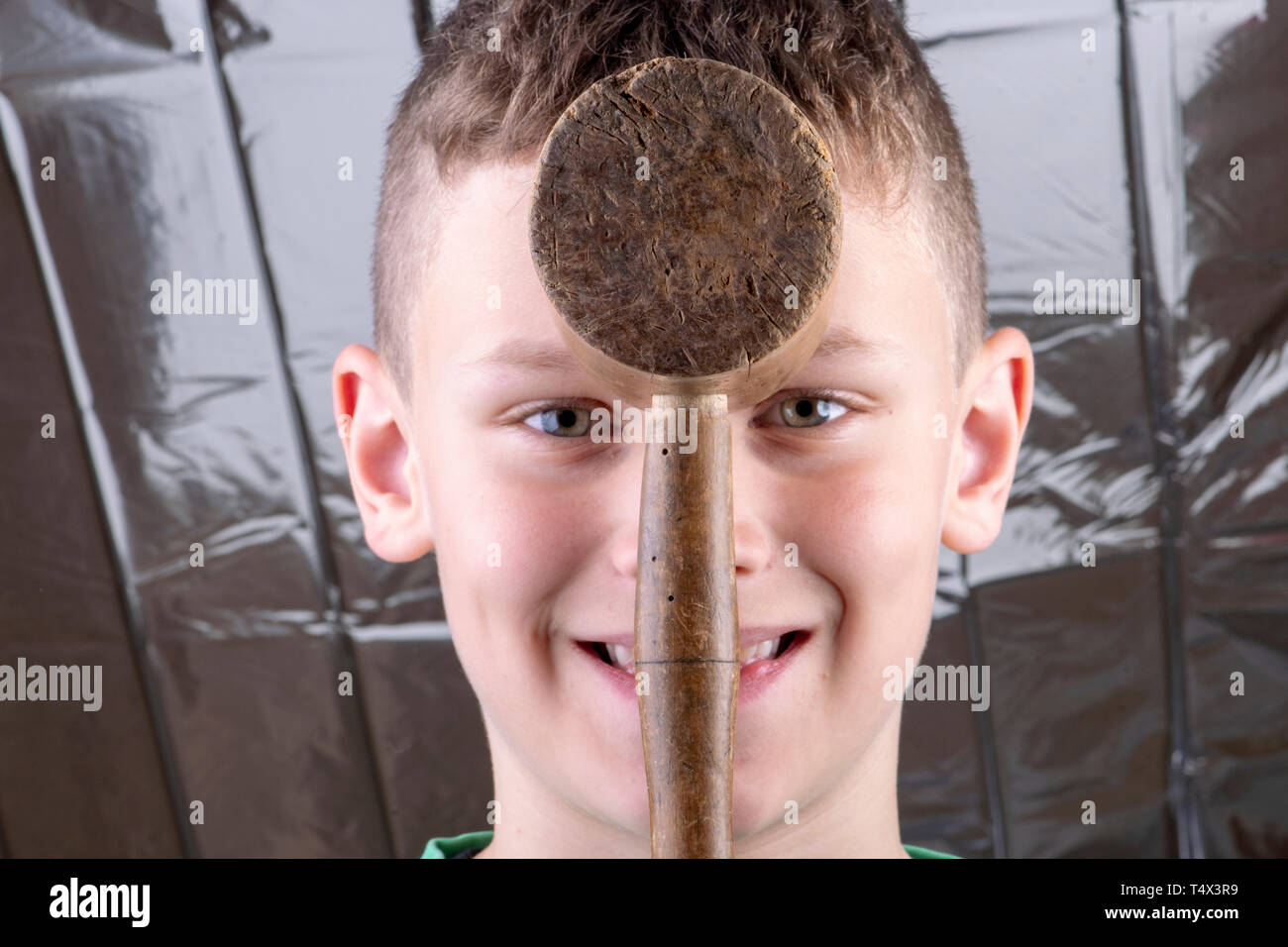 Boy hits himself on the head with a wooden hammer Stock Photo Alamy