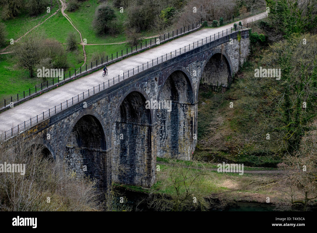 A man rides a bicycle across the Headstone Viaduct on the Monsal Trail in the Derbyshire Peak District. Stock Photo