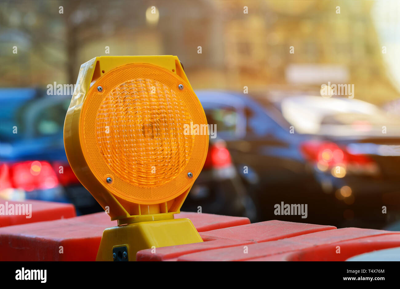 orange construction boards and flashing lights on city street Stock