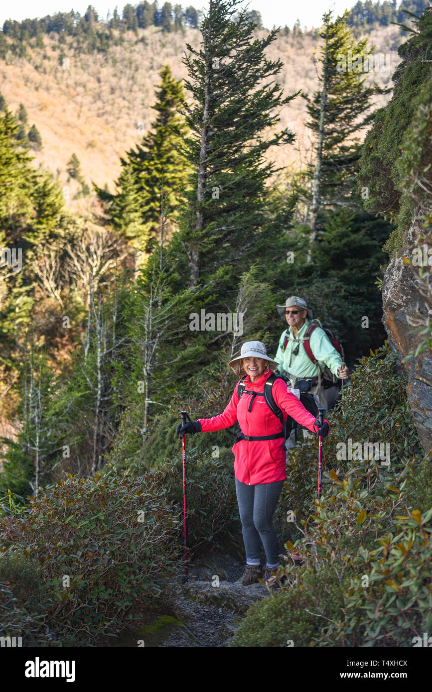 An adult fit elderly couple hiking along narrow trail at Charlies