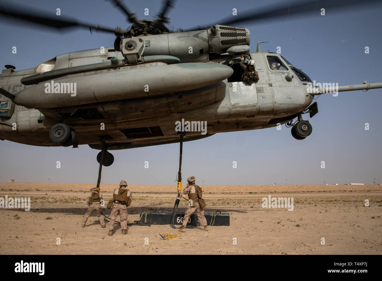 CAMP BEUHRING, Kuwait (April 11, 2019) A U.S. Marine CH-53E Super Stallion hovers while landing support specialists with the 22nd Marine Expeditionary Unit hook a 6,000 pound beam as part of helicopter support team training during Marine Expeditionary Unit Exercise. The Marines, with Marine Medium Tiltrotor Squadron 264 (Reinforced) and Combat Logistics Battalion 22, participated the training to build and sharpen their skills in order to maintain combat readiness. Marines and Sailors with the 22nd MEU and Kearsarge Amphibious Ready Group are currently deployed to the U.S. 5th Fleet area of ope Stock Photo