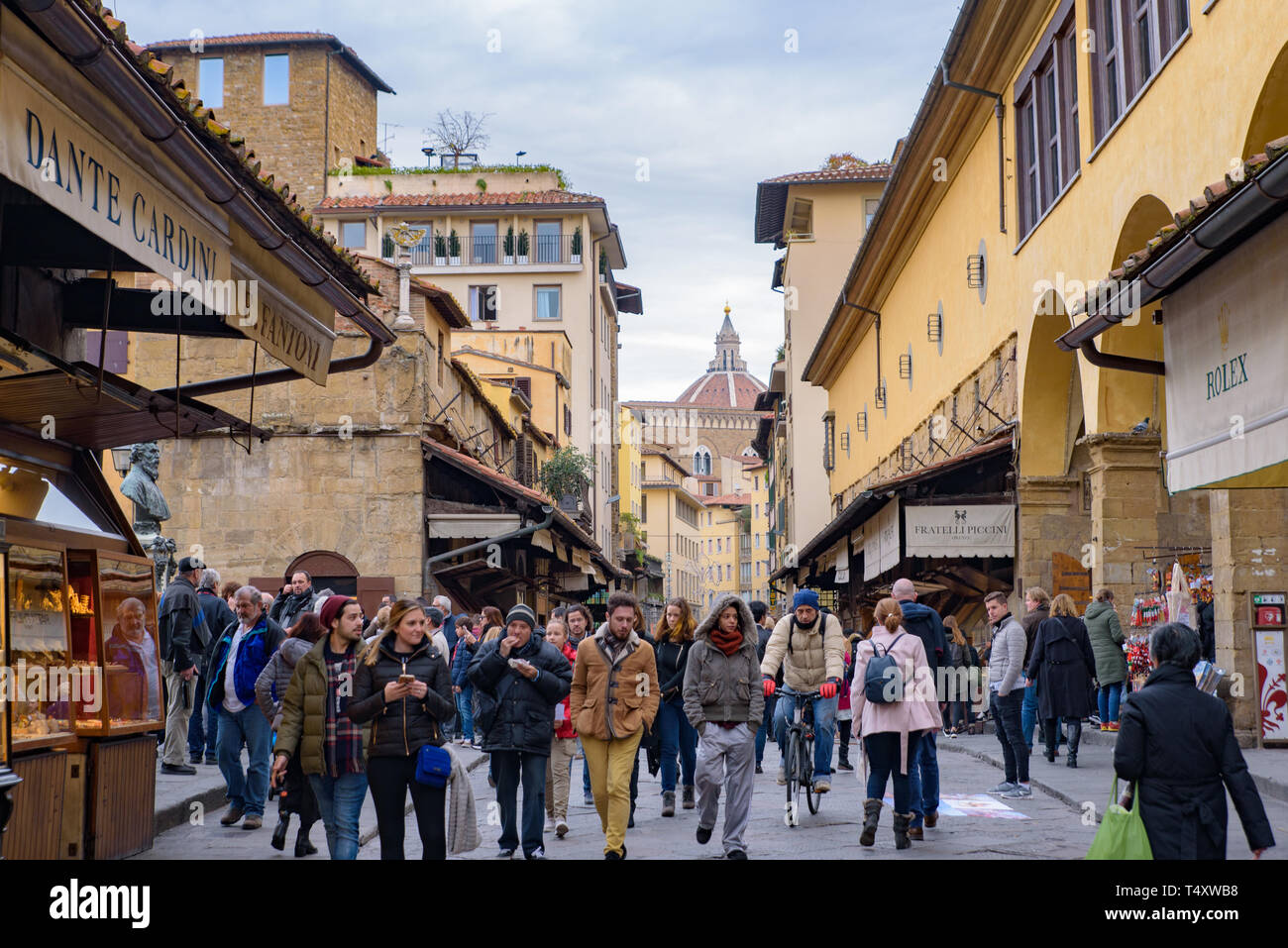 People walking on Ponte Vecchio (Old Bridge), a medieval stone bridge with shops on it, Florence, Italy Stock Photo