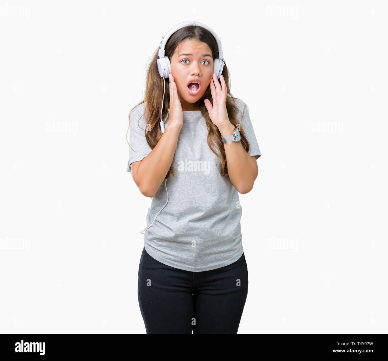 Young beautiful woman wearing headphones listening to music over ...