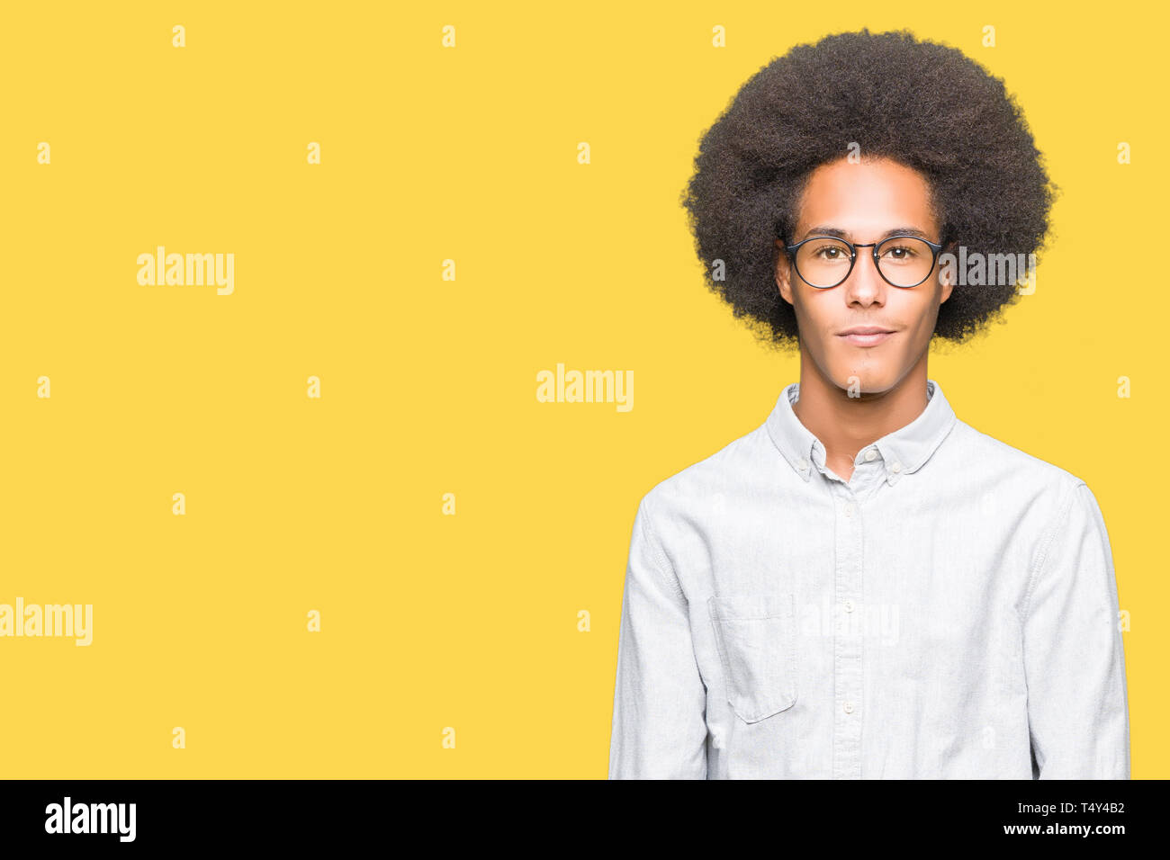 Young African American Man With Afro Hair Wearing Glasses Relaxed