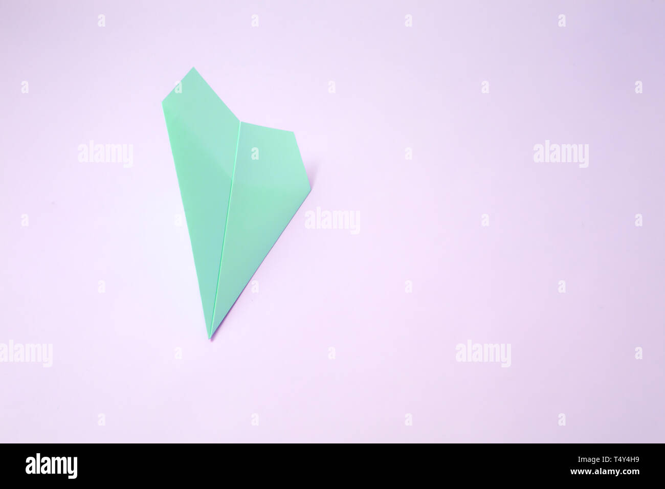 paper airplane on pastel background. Minimal flat lay school concept