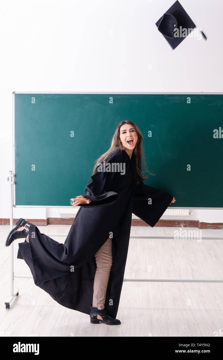 Female graduate student in front of green board Stock Photo - Alamy