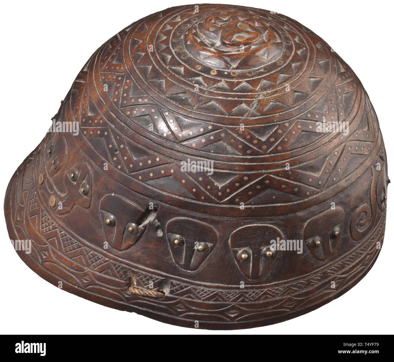 A carved wooden helmet, Chinese/Taiwanese, 19th century. One-piece helmet made from hardwood. The outside completely carved with stylised faces, geometrical decorations as well as a snake on the crown plate. Several continuous rows of inlaid copper and brass pins, some of them underlaid with horn discs. Two braided chin straps attached to the helmet. Diameter 20 cm. ++ historic, historical, China, Chinese, 19th century, Additional-Rights-Clearance-Info-Not-Available Stock Photo