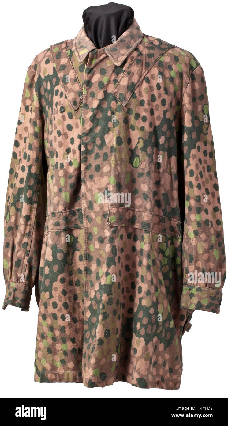 A 'Knochensack' in 'Erbstarn' camouflage pattern. Cotton cloth production from circa 1944, one side imprinted with 'Erbstarn' (pea dot) camouflage pattern. Covered button fly, Bakelite buttons (a few buttons missing), no zippers (flaps are sewn up), the sleeves with Prym push buttons, the reverse with a stitched-on pistol holster. Distinct marks from an SS eagle on the right of the front side. Grey inner liner. Doubtlessly an original piece and definitely one of the rarest SS uniform items, in obviously worn condition. historic, historical, 20th century, 1930s, 1940s, Waffe, Editorial-Use-Only Stock Photo